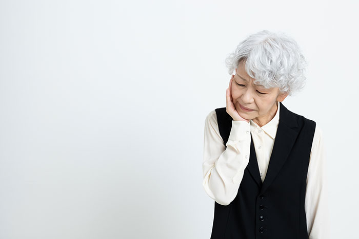 入れ歯に違和感を感じて悩む高齢女性