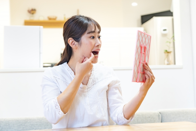 歯をいチェックする女性の画像