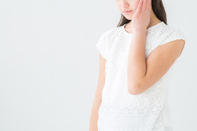頬をおさえる女の子