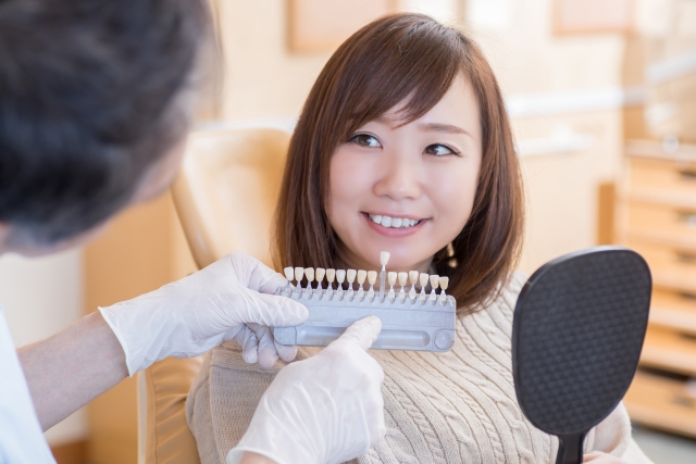 歯の色見本を見る女性
