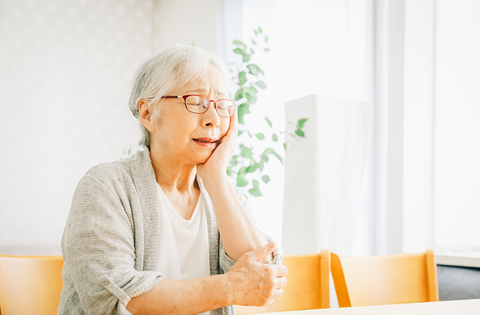 歯の補綴物が合わなくなってきて、歯が痛む高齢女性
