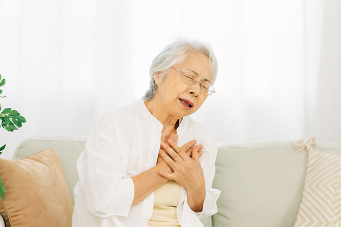 胸の痛みに苦しむ高齢女性